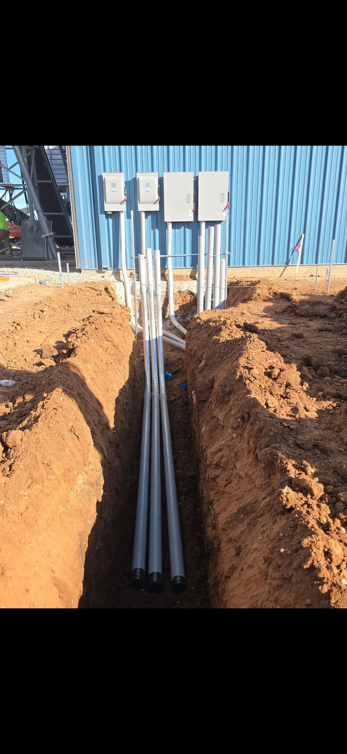 Underground PVC electrical conduit installation with junction boxes and trench work