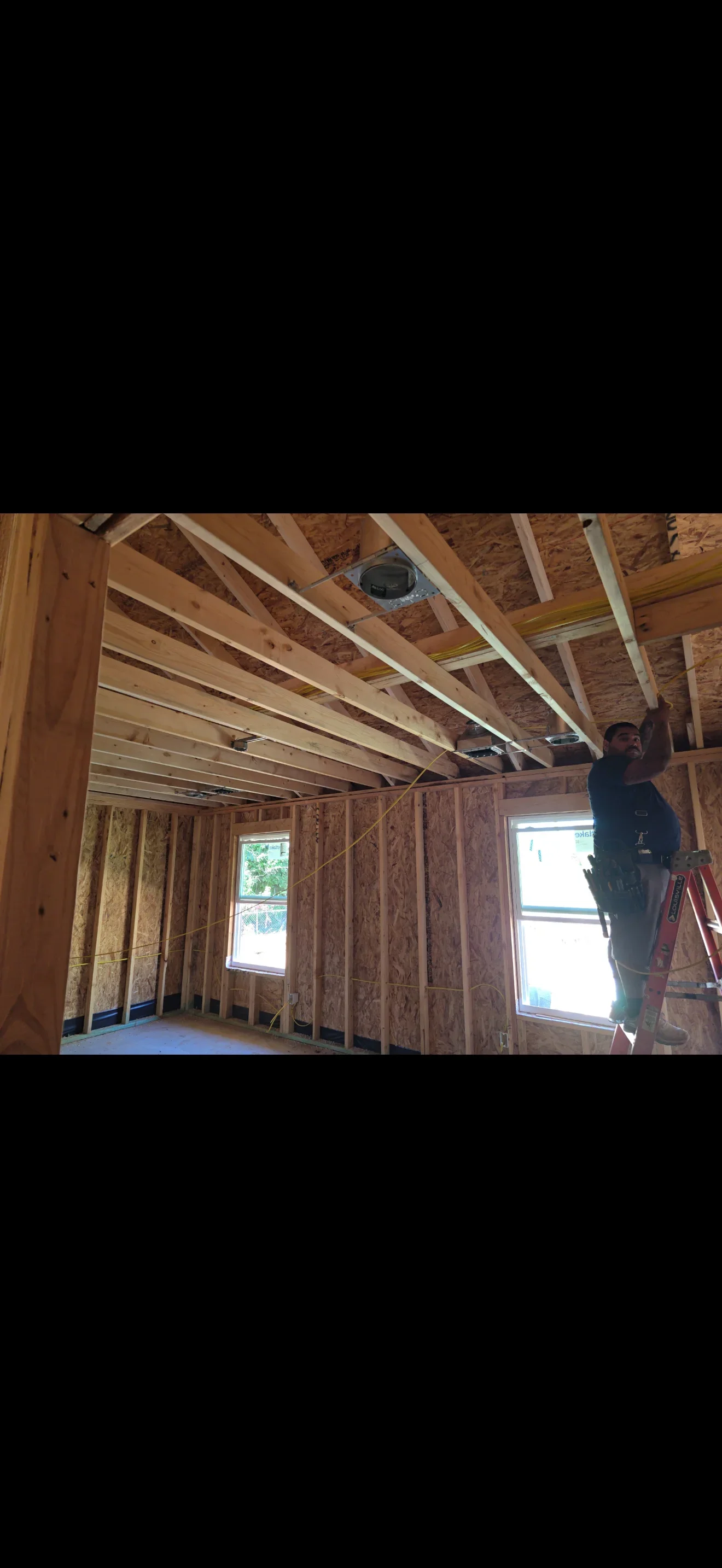 Electrical rough-in wiring installation in wood-framed residential construction with Romex cables and junction boxes