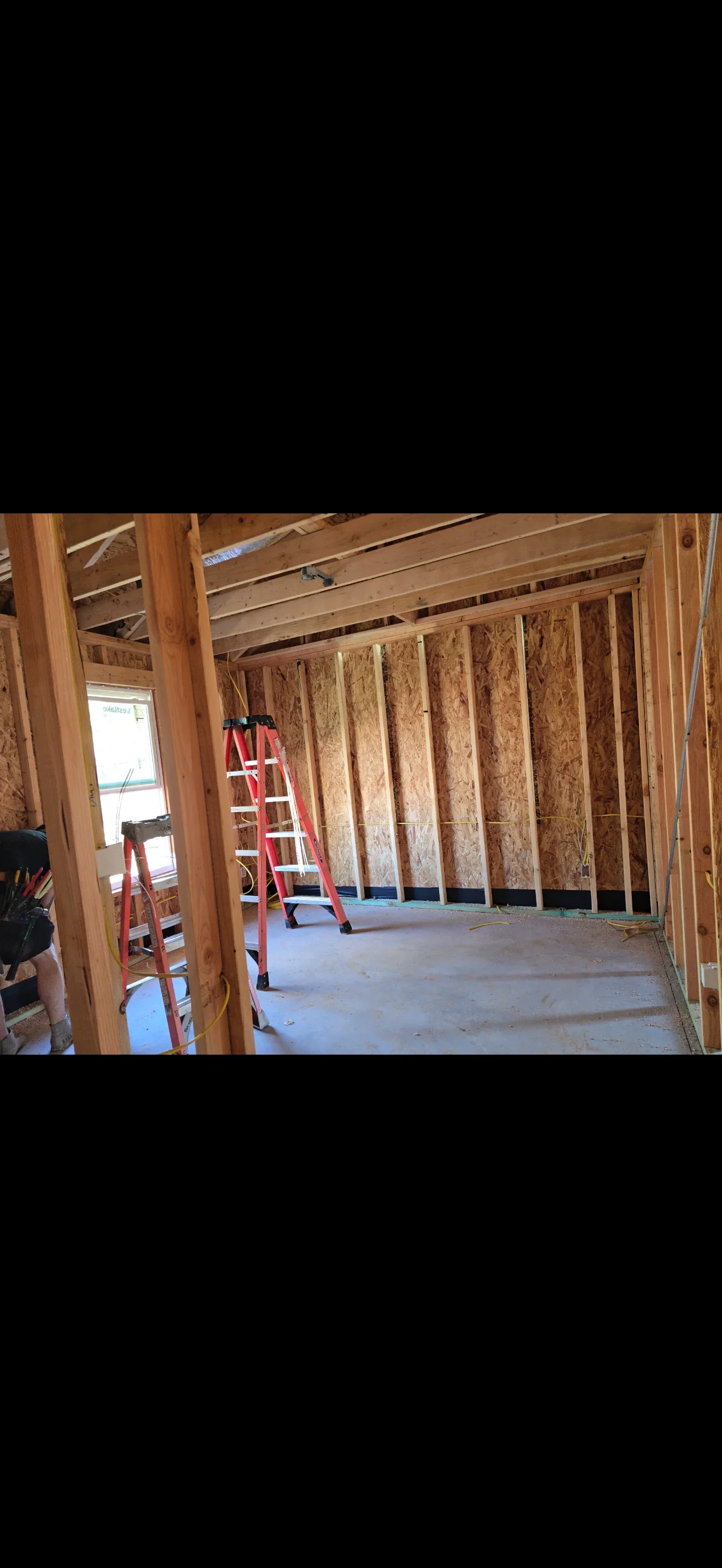 Electrical rough-in wiring installed in wood-framed walls and ceiling joists during construction
